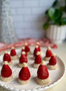 These delicious and healthy Strawberry Coconut Santa Hats are so simple and easy to make. With a no-bake coconut truffle base that the kids can pretty much make themselves.