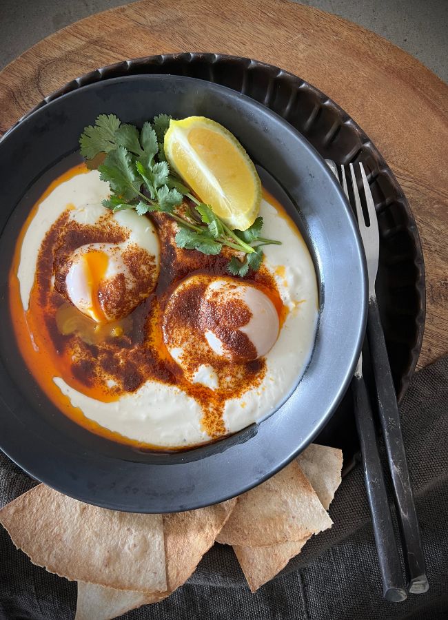 This Turkish Eggs recipe is a pretty special, indulgent breakfast...the eggs, are poached eggs on a bed of garlic yoghurt with spice-infused butter poured over.