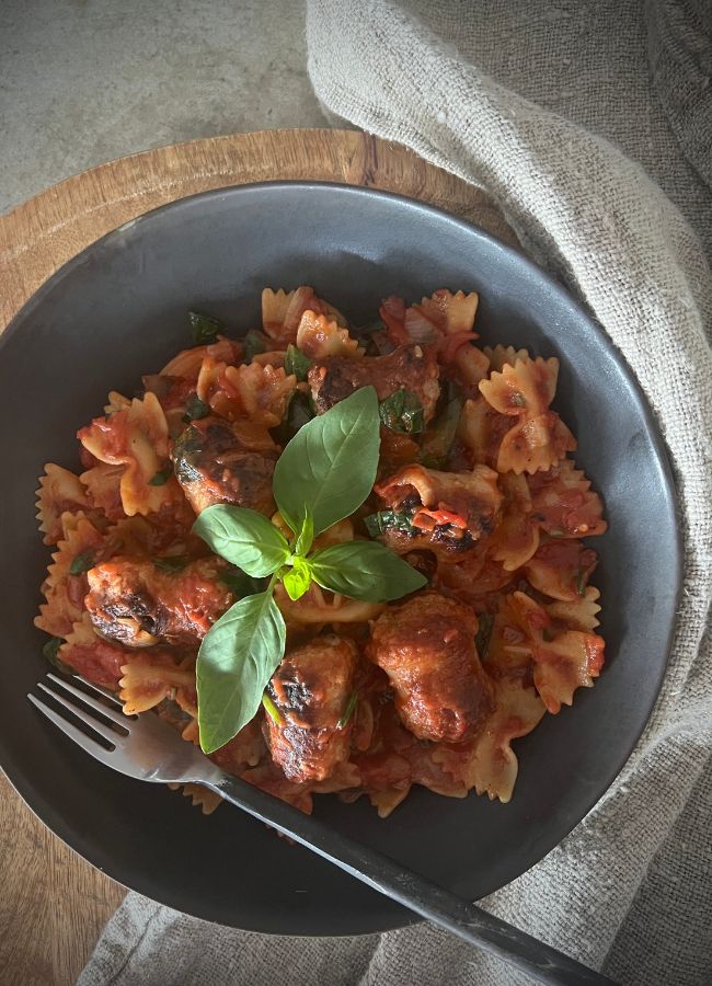 This easy one-pan sausage pasta is a delicious meal made with sausages (of choice) tomato sauce & fresh herbs. A perfect weeknight dinner!