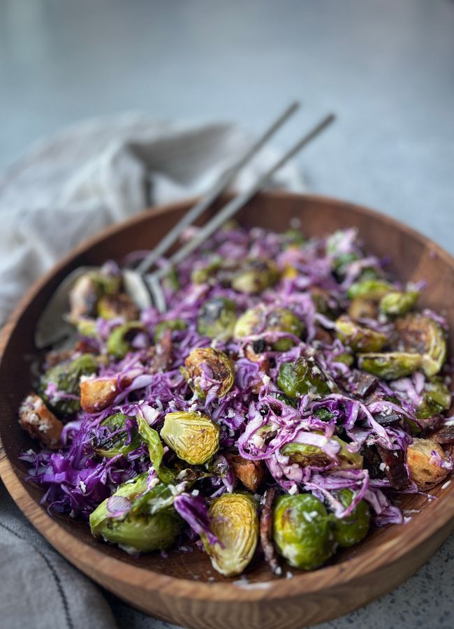 This Brussels Sprout Cabbage Salad combines roasted sprouts, crispy bacon, sourdough croutons, and a creamy, tangy dressing for a delicious twist on a Caesar-style salad.